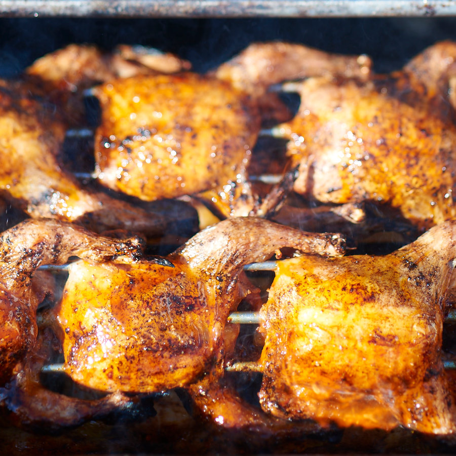 Chicken piri piri cooking over wood on the barbecue